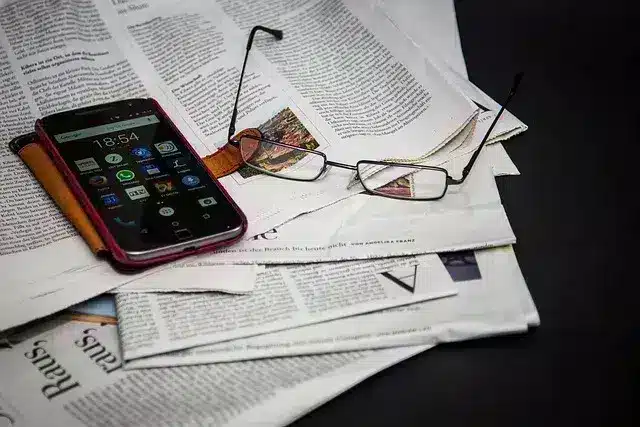 Periodico en blanco y negro con unas gafas y una calculadora encima